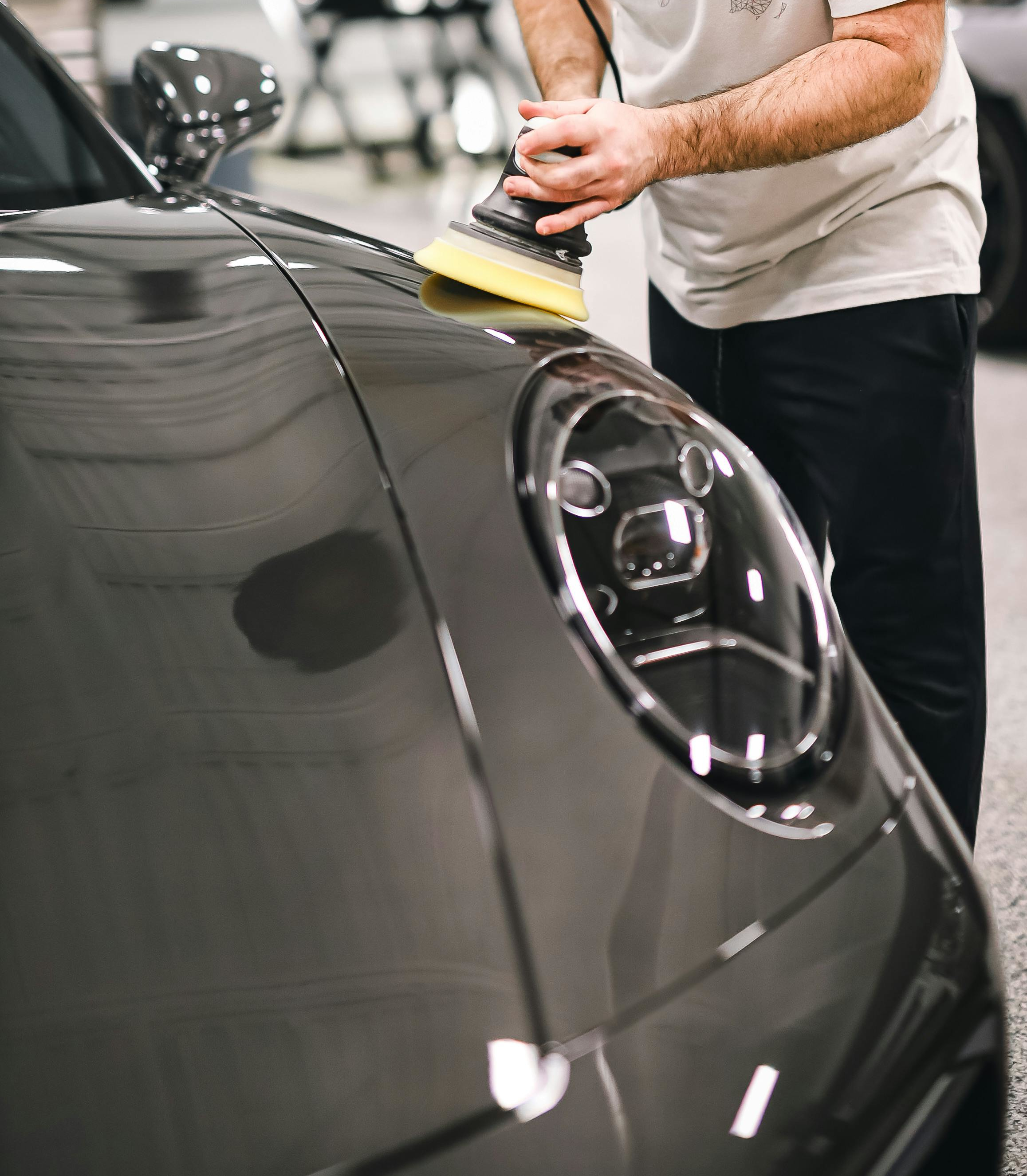 Technician refining paintwork under studio lighting