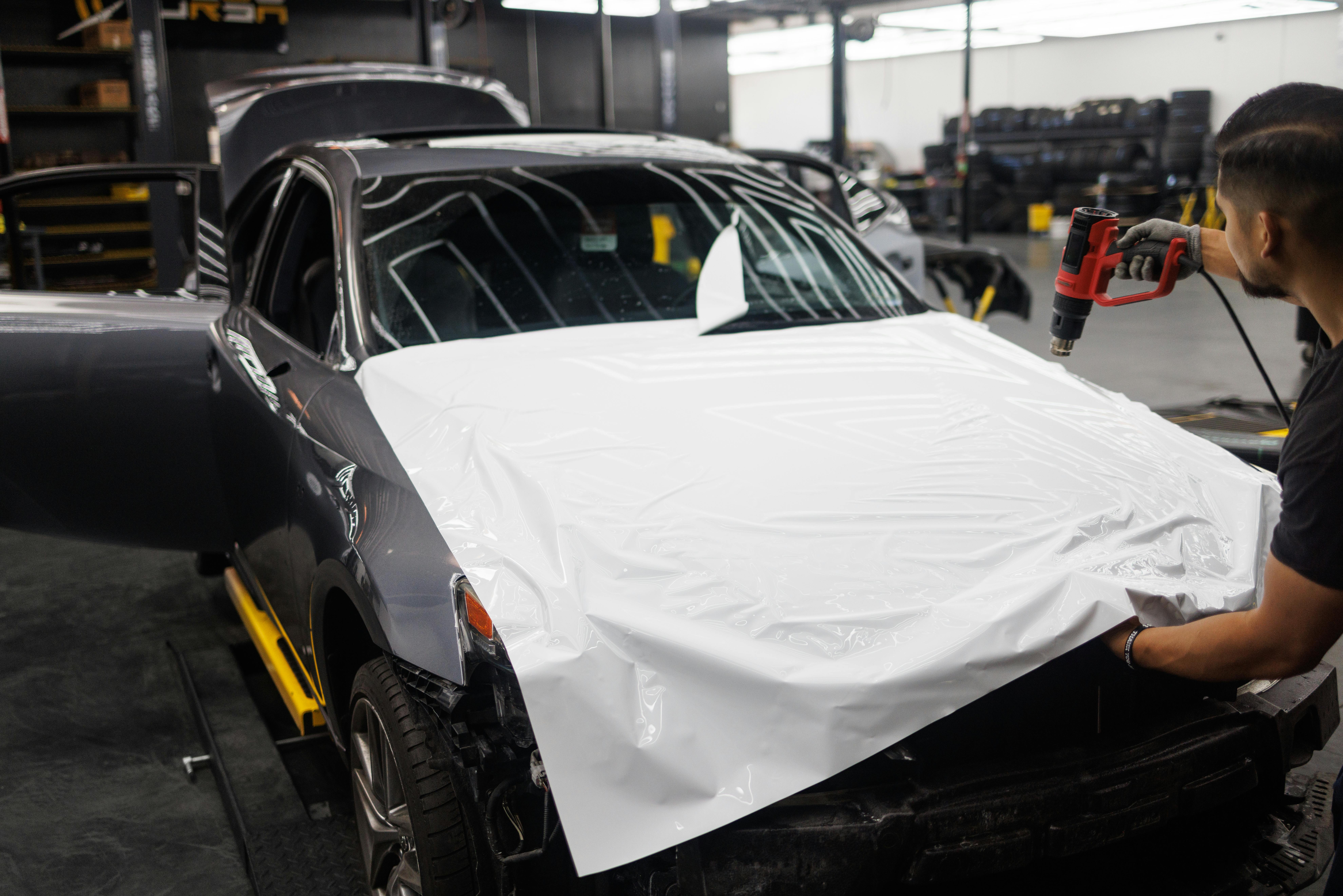 Installer floating paint protection film onto a performance SUV panel